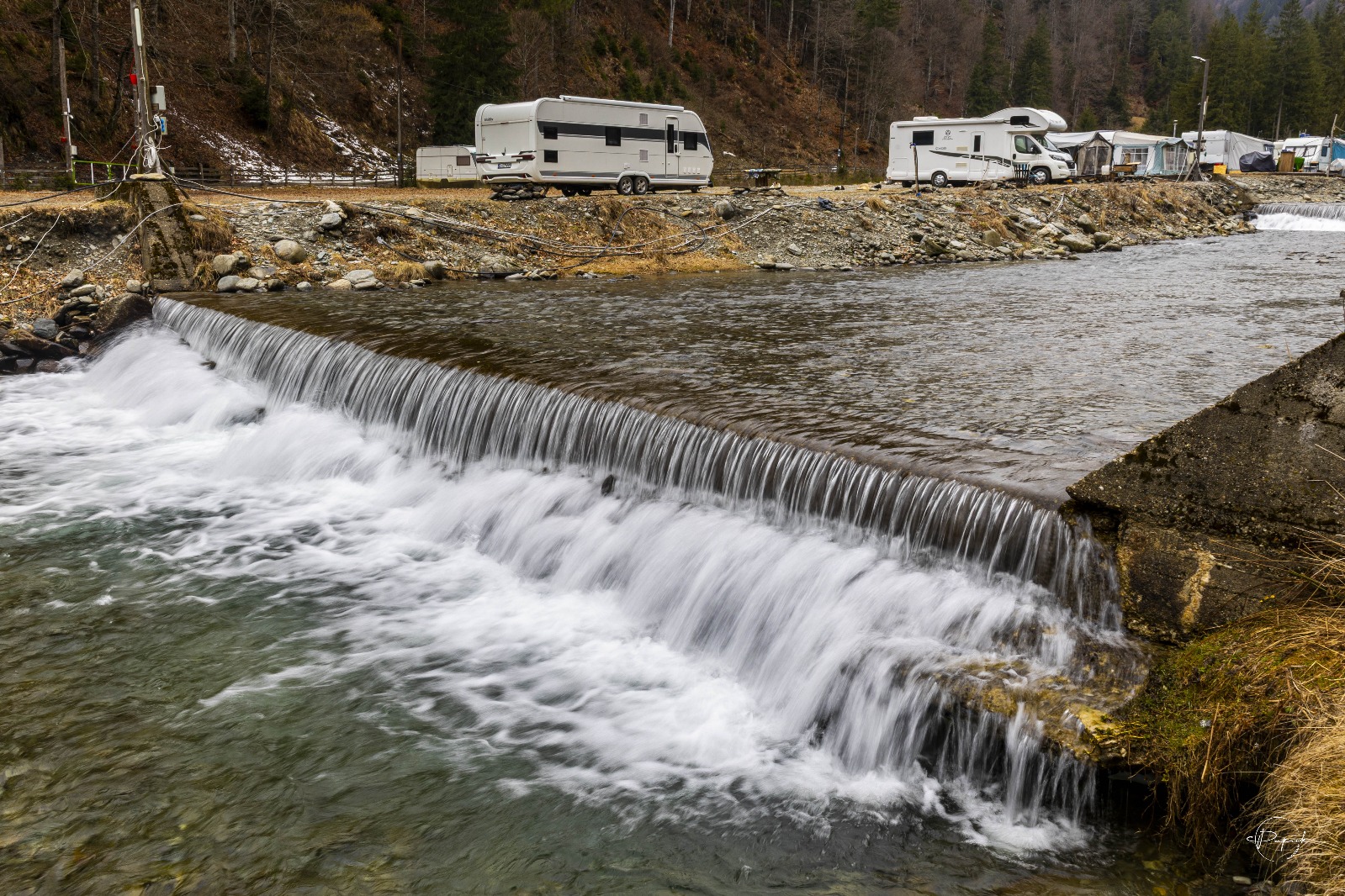 Rulote și autorulote amplasate în Camping Voina într-un peisaj montan spectaculos